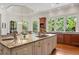 A bright kitchen featuring granite countertops, a central island, and a breakfast nook with expansive windows at 4634 Whitestone Way, Suwanee, GA 30024
