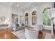 Open-concept living room with tall windows, a fireplace, elegant furniture, and hardwood flooring at 4634 Whitestone Way, Suwanee, GA 30024