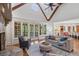 Open-concept living room with stone fireplace, exposed beams, and a view of the backyard and kitchen at 4634 Whitestone Way, Suwanee, GA 30024