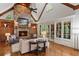 Vaulted living room featuring a stone fireplace, exposed wood beams, and large windows with natural light at 4634 Whitestone Way, Suwanee, GA 30024