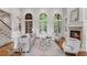 Elegant living room featuring a fireplace, large windows, and neutral furniture with hardwood floors at 4634 Whitestone Way, Suwanee, GA 30024