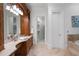 The main bath features a spacious stone countertop vanity and is adjacent to the walk-in closet at 4634 Whitestone Way, Suwanee, GA 30024