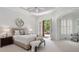 Light-filled primary bedroom with French doors to a patio and includes a sitting area and neutral decor at 4634 Whitestone Way, Suwanee, GA 30024