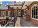 An outdoor kitchen with a stone countertop and grill are situated on a brick patio with arched windows at 4634 Whitestone Way, Suwanee, GA 30024
