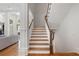 Elegant staircase features wood treads, white risers and banisters, and hardwood flooring on the main level at 4634 Whitestone Way, Suwanee, GA 30024