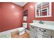 Cozy powder room features a traditional white vanity, a decorative wall rack, and warm paint at 4771 Summerwood Se Dr, Smyrna, GA 30126