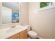 Clean half bathroom featuring a classic vanity and toilet, with a view of the shower at 4771 Summerwood Se Dr, Smyrna, GA 30126