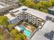 An aerial view of a condo building with a pool and many trees around it at 870 Inman Village Ne Pkwy # 305, Atlanta, GA 30307
