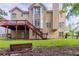 Expansive backyard with wooden deck, stairs, green lawn and a wooden bench at 1172 Oakhurst Trl, Lawrenceville, GA 30043
