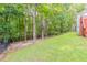 Lush backyard featuring a verdant lawn, tall trees, and a classic black fence at 1172 Oakhurst Trl, Lawrenceville, GA 30043