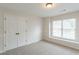 Bedroom features a large window, neutral carpeting, a closet, and great natural light at 1172 Oakhurst Trl, Lawrenceville, GA 30043