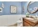 Stylish half-bathroom featuring wainscoting, unique mirror, and elegant fixtures at 130 Holly Reserve Pkwy, Canton, GA 30114