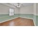 A well-lit bedroom featuring hardwood floors and neutral two-tone paint at 130 Holly Reserve Pkwy, Canton, GA 30114