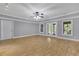 A large, empty bonus room featuring wood floors, a ceiling fan, and access to the backyard at 130 Holly Reserve Pkwy, Canton, GA 30114