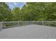 View of the spacious deck with gray wood and gray railings surrounded by trees at 130 Holly Reserve Pkwy, Canton, GA 30114