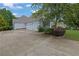 Spacious driveway leading to a three-car garage, surrounded by mature trees and landscaped areas at 130 Holly Reserve Pkwy, Canton, GA 30114