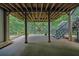 This covered patio has concrete flooring, wood supports, and a stairway to the backyard at 130 Holly Reserve Pkwy, Canton, GA 30114