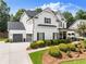 Beautiful two-story white home featuring a well-kept lawn, an attached garage, and tasteful landscaping at 2213 Independence Ln, Buford, GA 30519