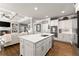 Bright kitchen features a spacious island, stainless steel appliances, hardwood floors and seamless connection to the living room at 2213 Independence Ln, Buford, GA 30519