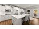 Charming white kitchen boasts an island with seating, stainless steel appliances, and easy access to the outdoor space at 2213 Independence Ln, Buford, GA 30519