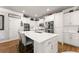 Stylish kitchen features white cabinets, stainless appliances, island with seating and modern lighting at 2213 Independence Ln, Buford, GA 30519