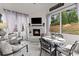 Bright sunroom with a stone fireplace, TV, and dining set overlooking the backyard at 2213 Independence Ln, Buford, GA 30519