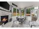 Bright sunroom with a stone fireplace, TV, and dining set overlooking the backyard at 2213 Independence Ln, Buford, GA 30519