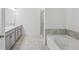 Modern bathroom with double vanity, tiled floor, glass enclosed shower and soaking tub at 377 Danville Ave, Suwanee, GA 30024