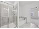 Modern bathroom featuring walk-in shower, soaking tub, tiled floors and grey accent wall at 377 Danville Ave, Suwanee, GA 30024