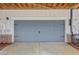 Attached two-car garage with carriage doors, exterior lighting, and brick siding at 377 Danville Ave, Suwanee, GA 30024