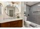Modern bathroom with stylish vanity, round mirror, and tiled shower with built-in niche at 515 Dover St, Marietta, GA 30066