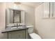 Basement bathroom with a gray vanity, brushed gold faucet, a framed mirror with lights, and a standard toilet at 515 Dover St, Marietta, GA 30066