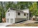 Stylish home exterior with a two-car garage and deck is nestled within a lush, green, wooded landscape at 515 Dover St, Marietta, GA 30066