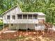 Rear exterior view showcasing a raised two-story home with a back porch overlooking the private wooded lot at 515 Dover St, Marietta, GA 30066