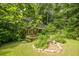 Lush backyard surrounded by vibrant trees, featuring a charming stone-lined garden bed at 5848 Kingswood Ct, Norcross, GA 30093