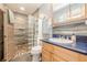 Bathroom featuring a tiled shower with a glass block wall, vanity, sink, and decorative accents, offering a modern and stylish space at 5848 Kingswood Ct, Norcross, GA 30093