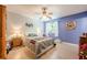 A well-lit bedroom with hardwood floors has a blue accent wall and a ceiling fan at 5848 Kingswood Ct, Norcross, GA 30093