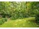 Beautiful green lawn with mature shade trees and a wooded perimeter at 5848 Kingswood Ct, Norcross, GA 30093