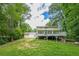 Expansive backyard featuring a large deck, storage building, and lush greenery at 5868 Kingswood Nw Ct, Norcross, GA 30093