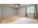 This bedroom features a ceiling fan, gray walls, and lots of light at 5868 Kingswood Nw Ct, Norcross, GA 30093