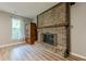 View of the brick fireplace featuring a dark wood beam and luxury vinyl plank flooring at 5868 Kingswood Nw Ct, Norcross, GA 30093