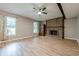 Living room with a brick fireplace, a dark wood beam and luxury vinyl plank flooring at 5868 Kingswood Nw Ct, Norcross, GA 30093