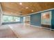 Sunroom with natural light, featuring a light wooden ceiling, blue accent wall and large glass doors at 5868 Kingswood Nw Ct, Norcross, GA 30093