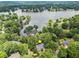 Aerial view of a home on a tree-lined street with lake views in distance at 121 Clipper Bay Drive, Alpharetta, GA 30005