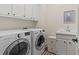 Well-equipped laundry room with washer, dryer, and storage cabinets at 121 Clipper Bay Drive, Alpharetta, GA 30005