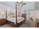 This main bedroom features a tray ceiling, ceiling fan, and a four-poster bed with matching furniture at 121 Clipper Bay Drive, Alpharetta, GA 30005