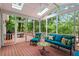 This screened-in porch is furnished with colorful patio furniture and offers wooded views at 121 Clipper Bay Drive, Alpharetta, GA 30005