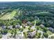 Aerial view of neighborhood with mature trees, golf course, lake, manicured lawns, and winding roads at 1232 Everton Pl, Cumming, GA 30041