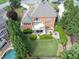 Aerial view of brick home, large yard, beautiful landscaping and in-ground pool at 1232 Everton Pl, Cumming, GA 30041