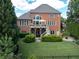 Large brick home with a large well-manicured backyard, deck and covered patio perfect for outdoor living at 1232 Everton Pl, Cumming, GA 30041